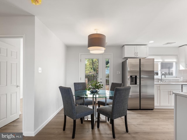 dining area with light wood-type flooring and sink