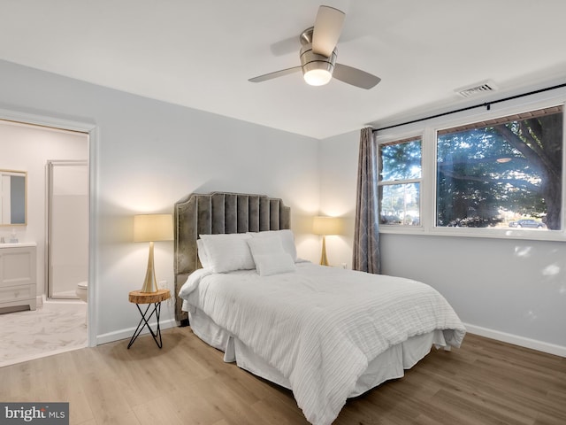 bedroom with ensuite bathroom, wood-type flooring, and ceiling fan