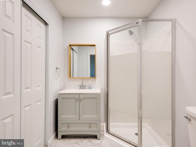 bathroom with a shower with shower door, vanity, and toilet