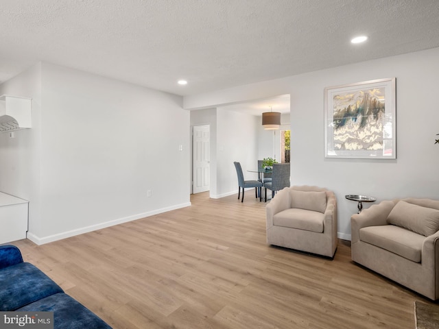 living area featuring light hardwood / wood-style flooring and a textured ceiling