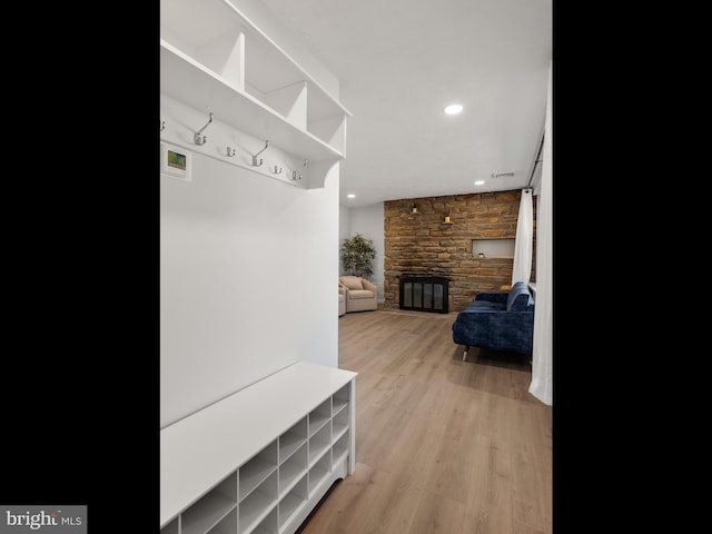 mudroom featuring a fireplace and light hardwood / wood-style flooring