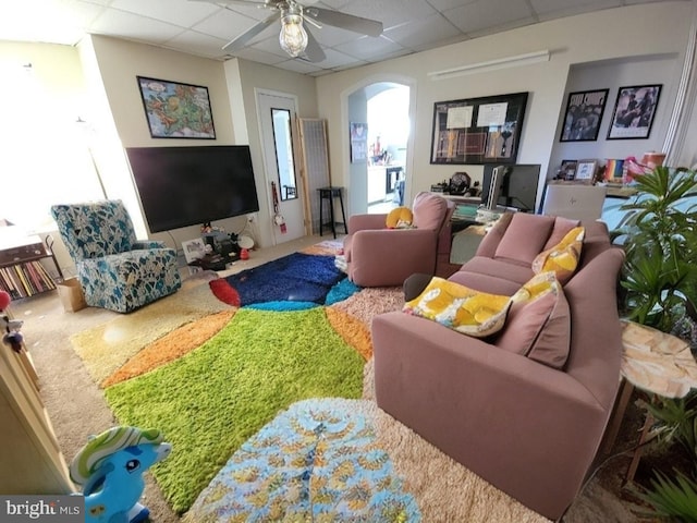 living room featuring ceiling fan and a paneled ceiling