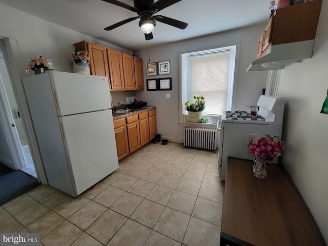 kitchen featuring ceiling fan, light tile patterned floors, radiator heating unit, gas range oven, and white refrigerator