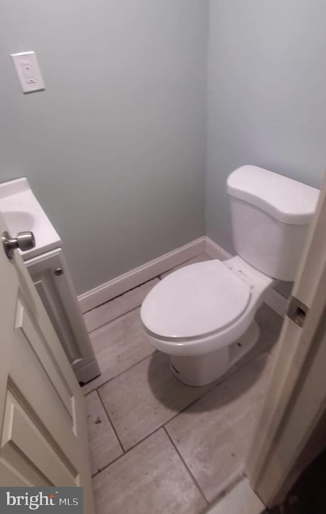 bathroom featuring toilet, vanity, and tile patterned flooring