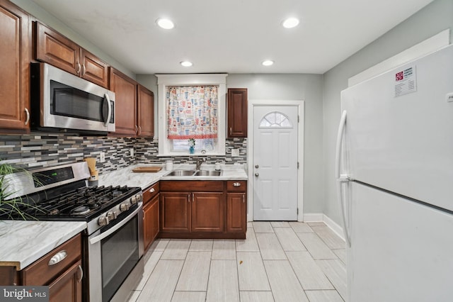 kitchen with sink, appliances with stainless steel finishes, and tasteful backsplash