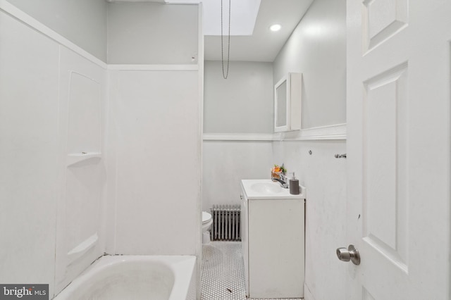 bathroom featuring vanity, radiator heating unit, tile patterned floors, toilet, and a bathtub