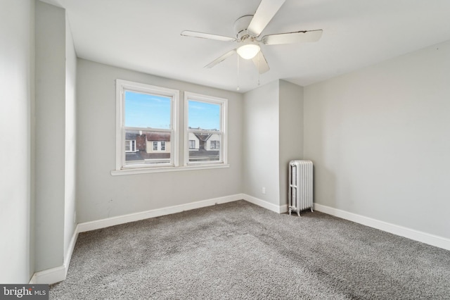 carpeted empty room with radiator and ceiling fan