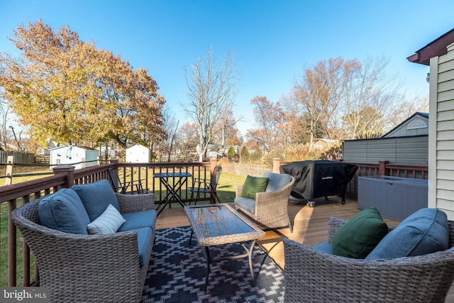 deck with area for grilling, a storage shed, an outdoor living space, and a yard