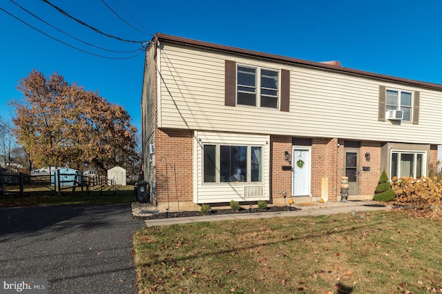 view of front of property with cooling unit and a front yard