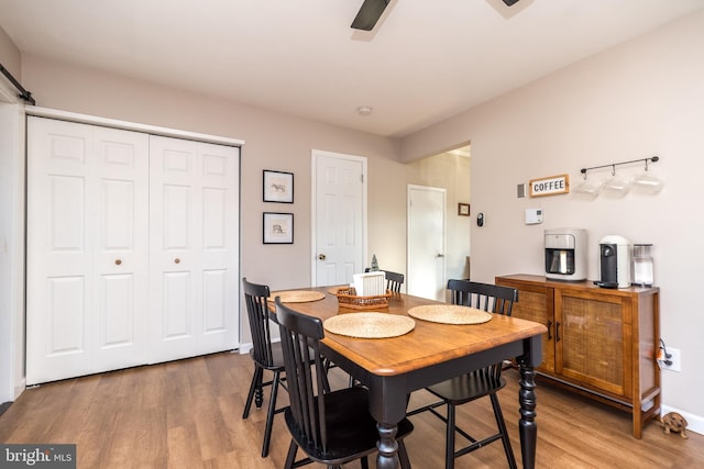 dining space with hardwood / wood-style flooring and ceiling fan