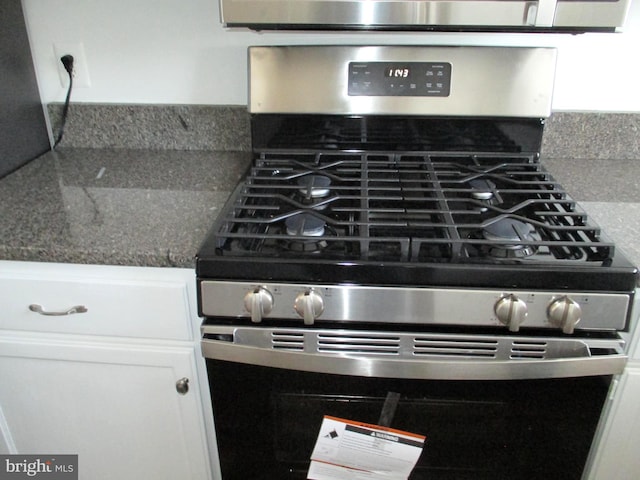 details featuring white cabinetry and stainless steel gas range oven