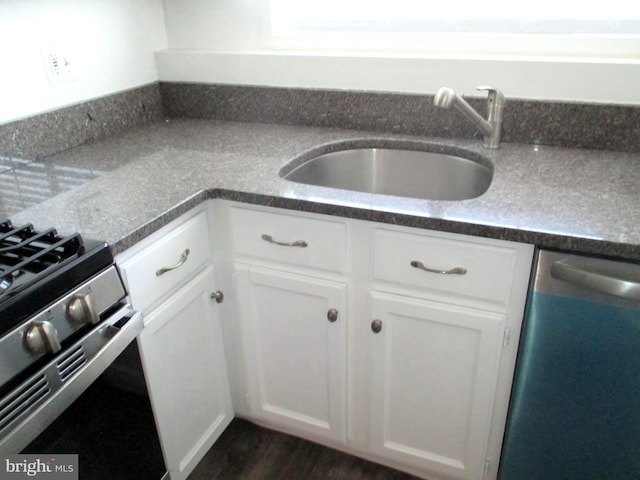 kitchen featuring dark wood-type flooring, white cabinetry, appliances with stainless steel finishes, and sink