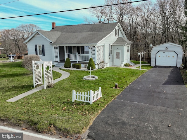 view of front of property with a garage, a front yard, covered porch, and an outdoor structure