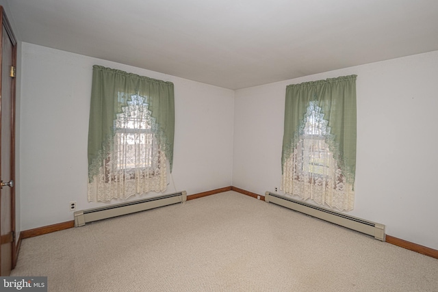 spare room featuring baseboard heating and carpet flooring