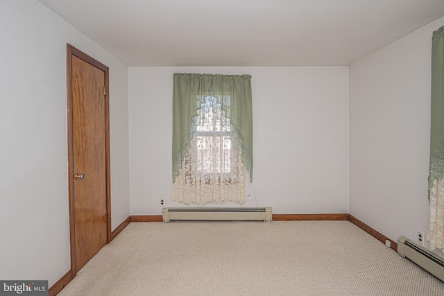 carpeted empty room featuring baseboard heating