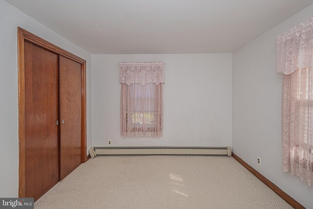 bedroom with carpet, a baseboard radiator, and a closet