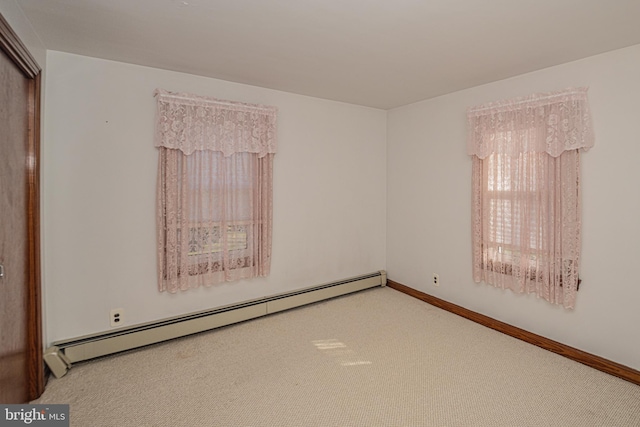 carpeted spare room featuring baseboard heating