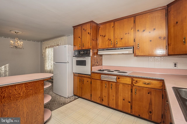 kitchen with backsplash, hanging light fixtures, sink, an inviting chandelier, and white appliances