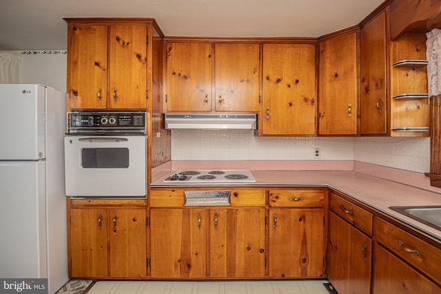 kitchen featuring backsplash and white appliances