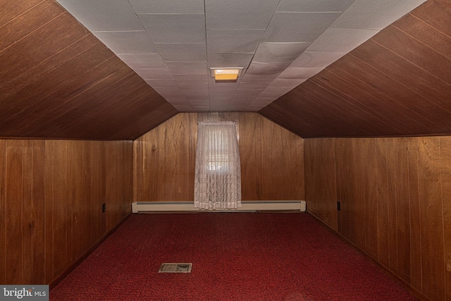 bonus room with wood walls, vaulted ceiling, and dark carpet