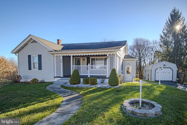 view of front of property featuring a front lawn, a garage, covered porch, and an outdoor structure