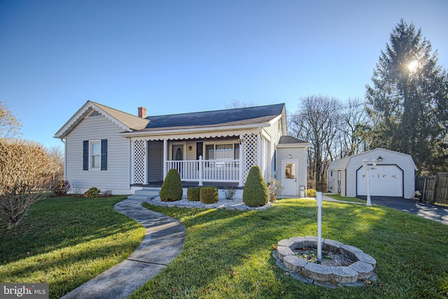 ranch-style home featuring an outbuilding, a garage, a front lawn, and a porch