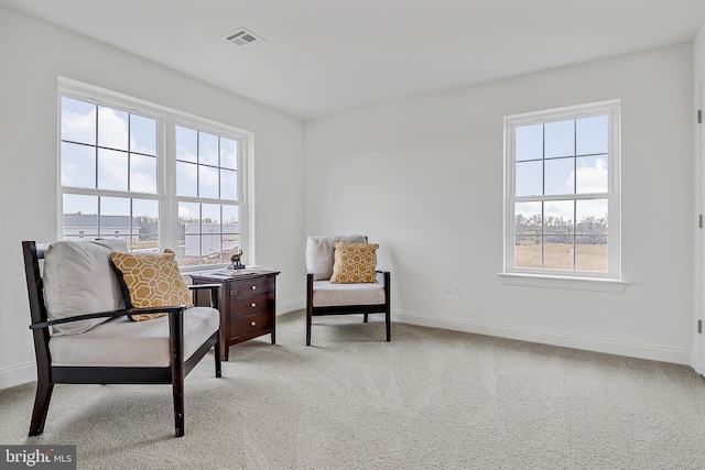 living area featuring carpet flooring, baseboards, and visible vents