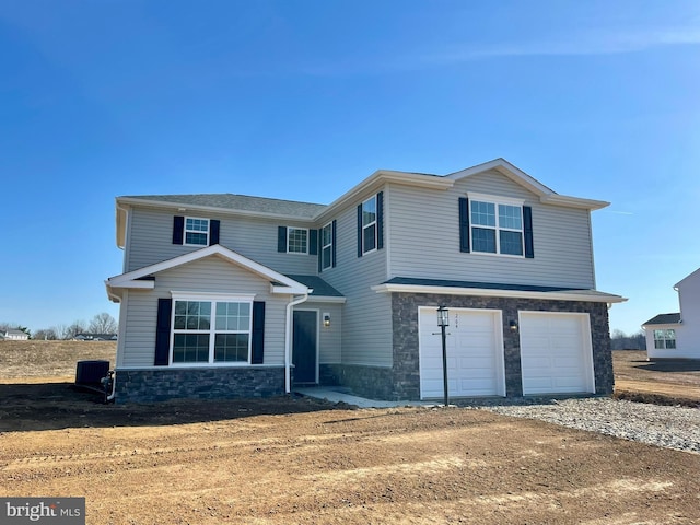 view of front facade featuring stone siding, an attached garage, and dirt driveway