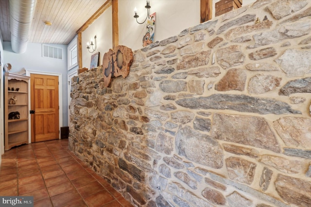 hall featuring dark tile patterned floors and wooden ceiling