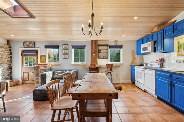 kitchen with tasteful backsplash, blue cabinetry, a skylight, pendant lighting, and white appliances