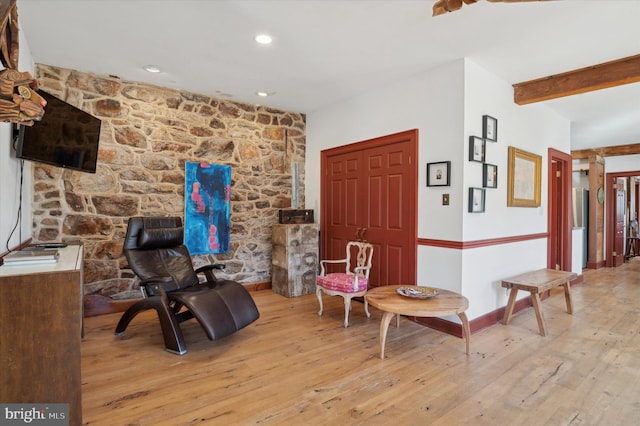 living area featuring light hardwood / wood-style floors and beamed ceiling