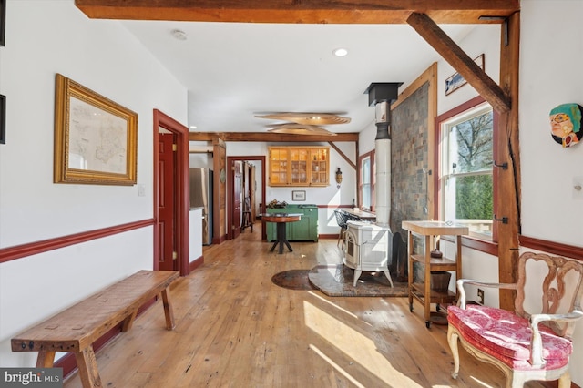 hall with beamed ceiling and light hardwood / wood-style flooring