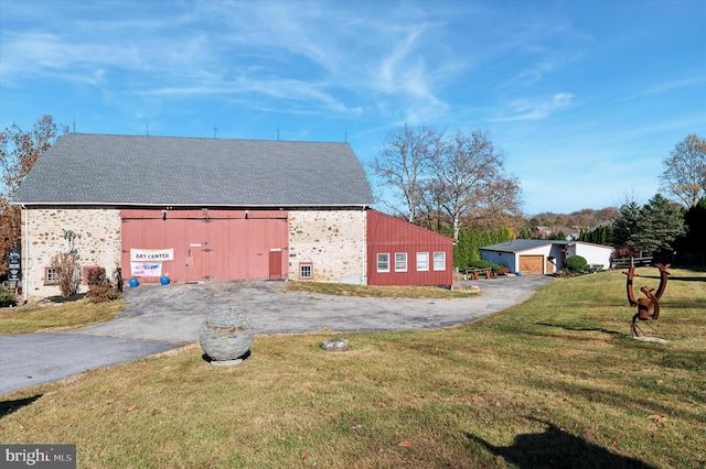 view of side of home with an outdoor structure and a lawn