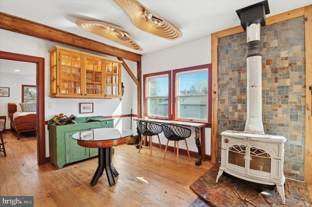 interior space with a wood stove, light hardwood / wood-style flooring, and tile walls