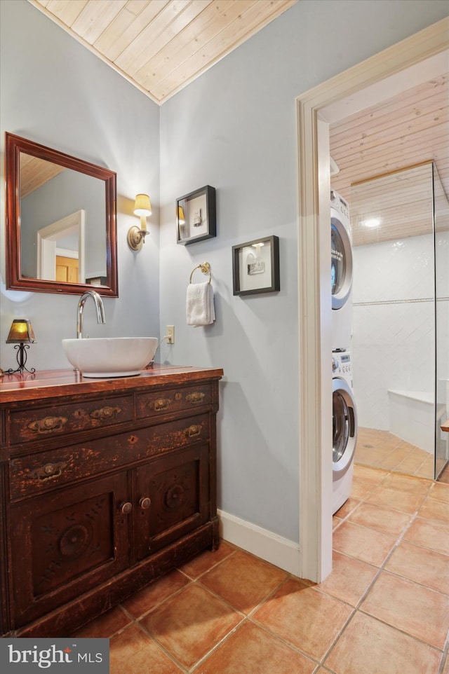 bathroom with stacked washer / dryer, tile patterned floors, vanity, and wooden ceiling