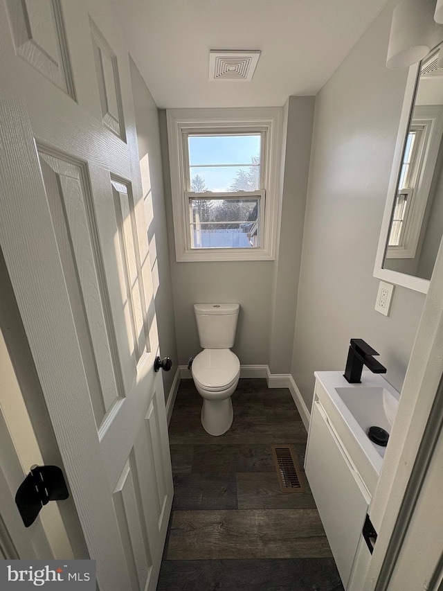 bathroom with vanity, wood-type flooring, and toilet