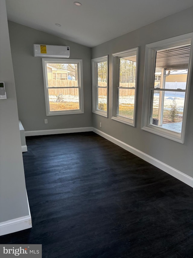 empty room featuring vaulted ceiling and a wall unit AC