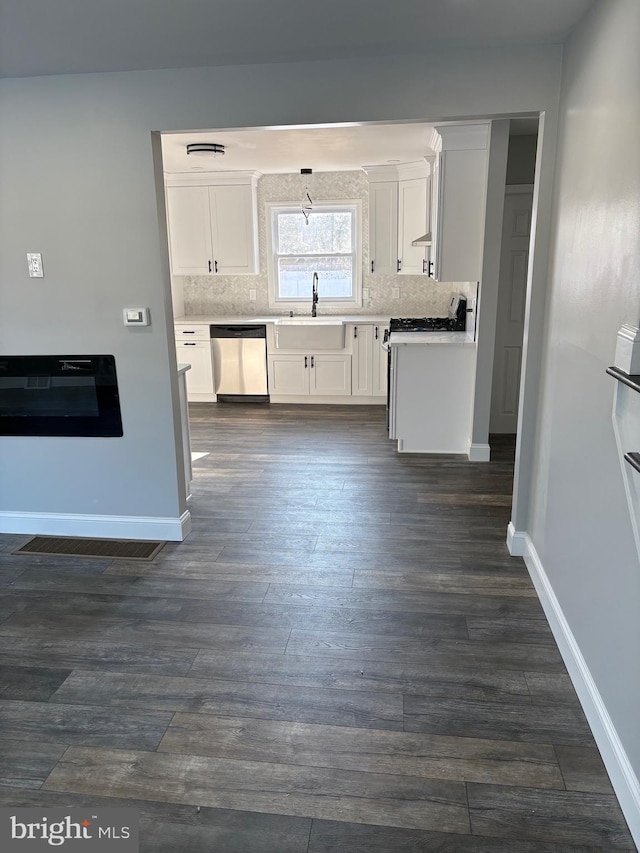 kitchen featuring sink, white range with gas stovetop, dishwasher, backsplash, and white cabinets