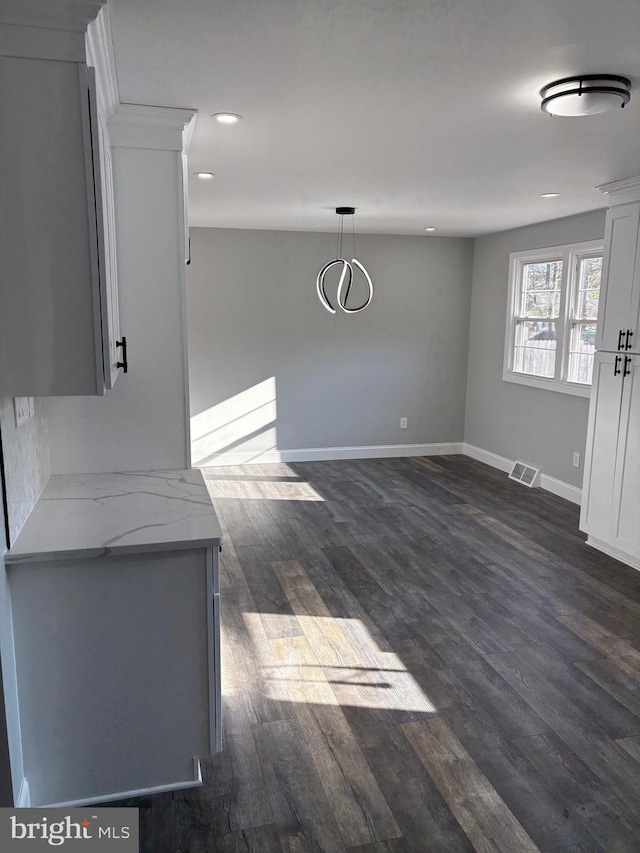 unfurnished dining area featuring dark hardwood / wood-style flooring