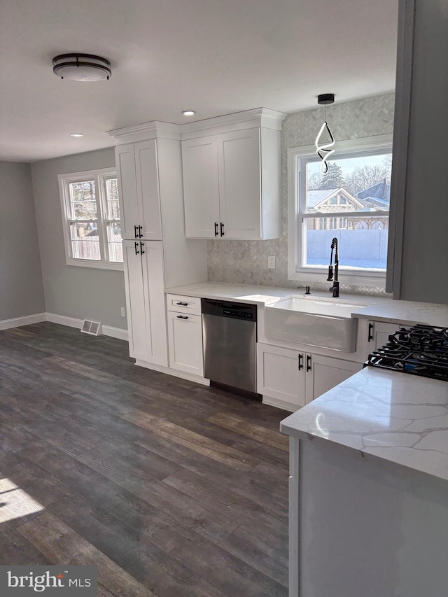 kitchen with decorative light fixtures, dishwasher, sink, and white cabinets