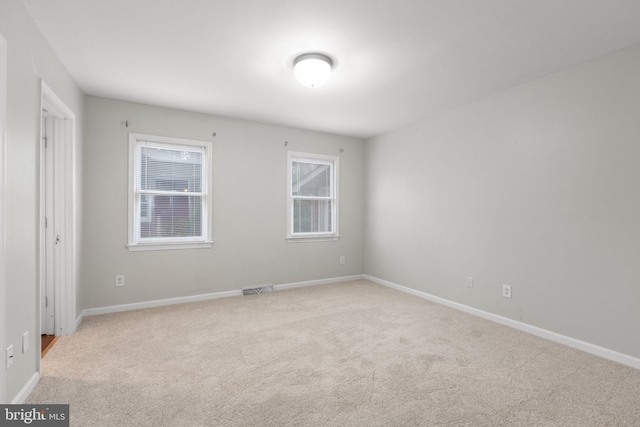 spare room featuring light carpet