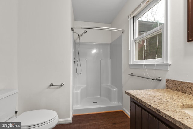 bathroom featuring hardwood / wood-style flooring, toilet, vanity, and walk in shower