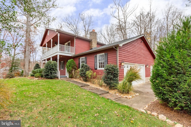 view of front of property featuring a balcony, a front yard, and a garage