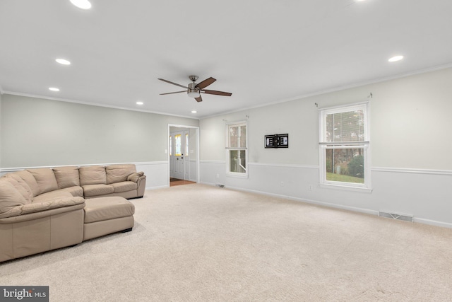 carpeted living room with crown molding and ceiling fan