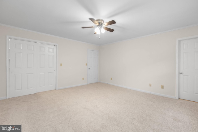 unfurnished bedroom featuring light colored carpet, ceiling fan, and ornamental molding