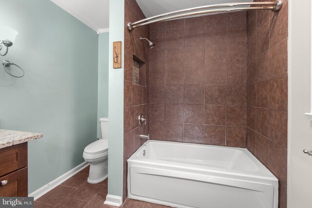 full bathroom featuring vanity, tile patterned floors, tiled shower / bath combo, toilet, and ornamental molding