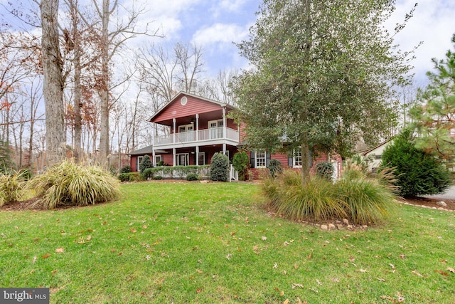 view of yard with covered porch and a balcony