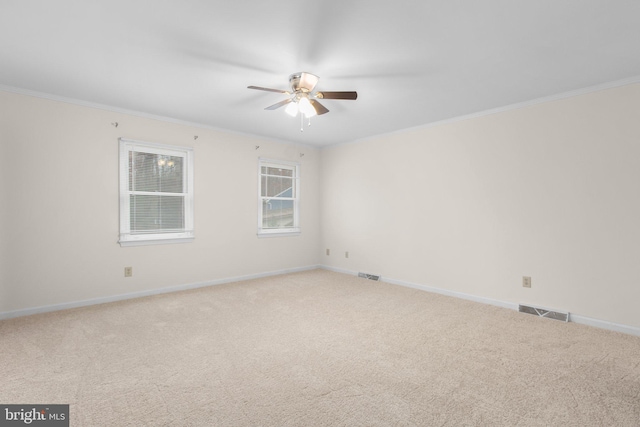 unfurnished room featuring crown molding, ceiling fan, and light colored carpet