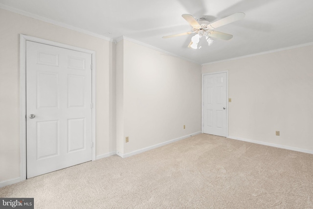 unfurnished room with light colored carpet, ceiling fan, and crown molding