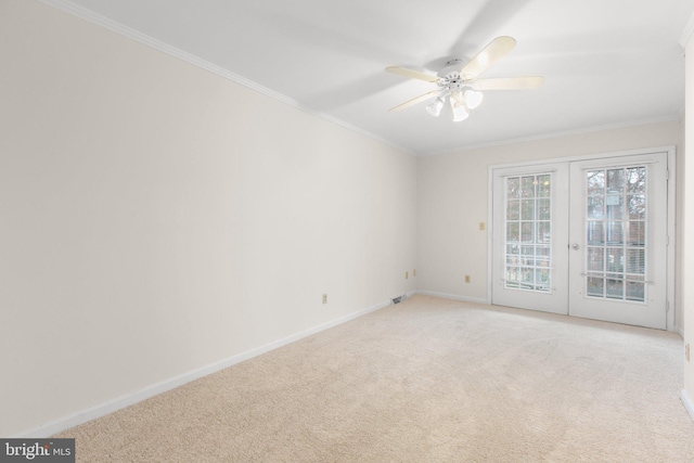 unfurnished room featuring light carpet, french doors, ceiling fan, and ornamental molding